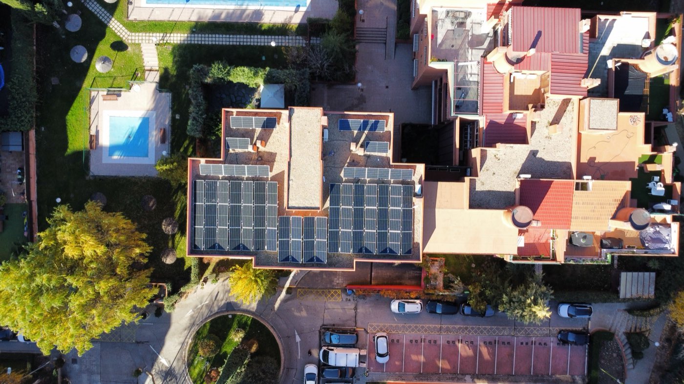 Vista aérea de varias cubiertas con placas solares en una urbanización